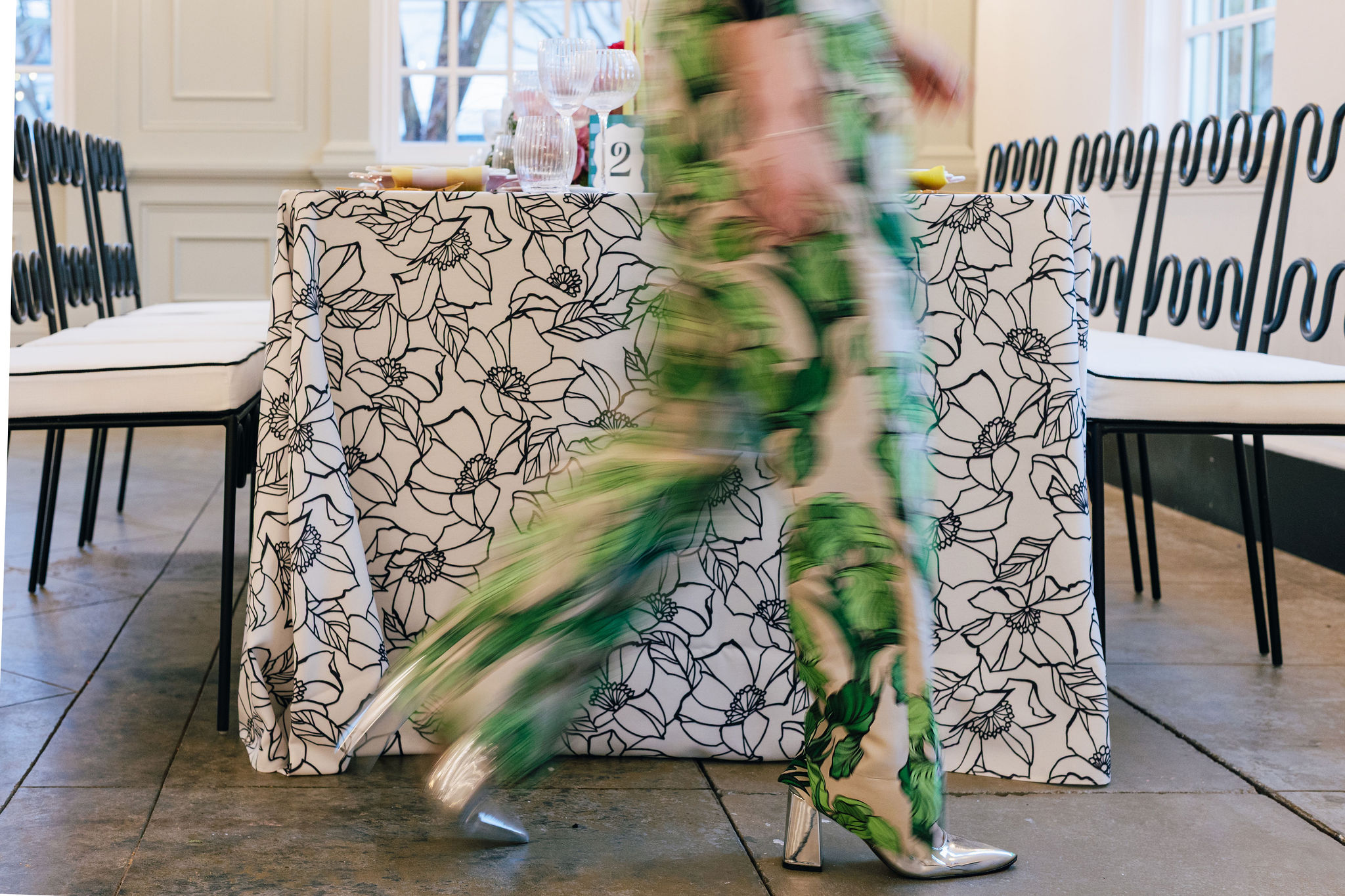 Event planner Baylye Burnette walking in front of a set table.