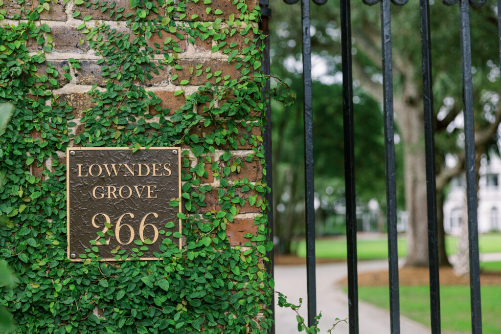 The gate of Lowndes Grove in Charleston, South Carolina featuring climbing fig on brick posts.