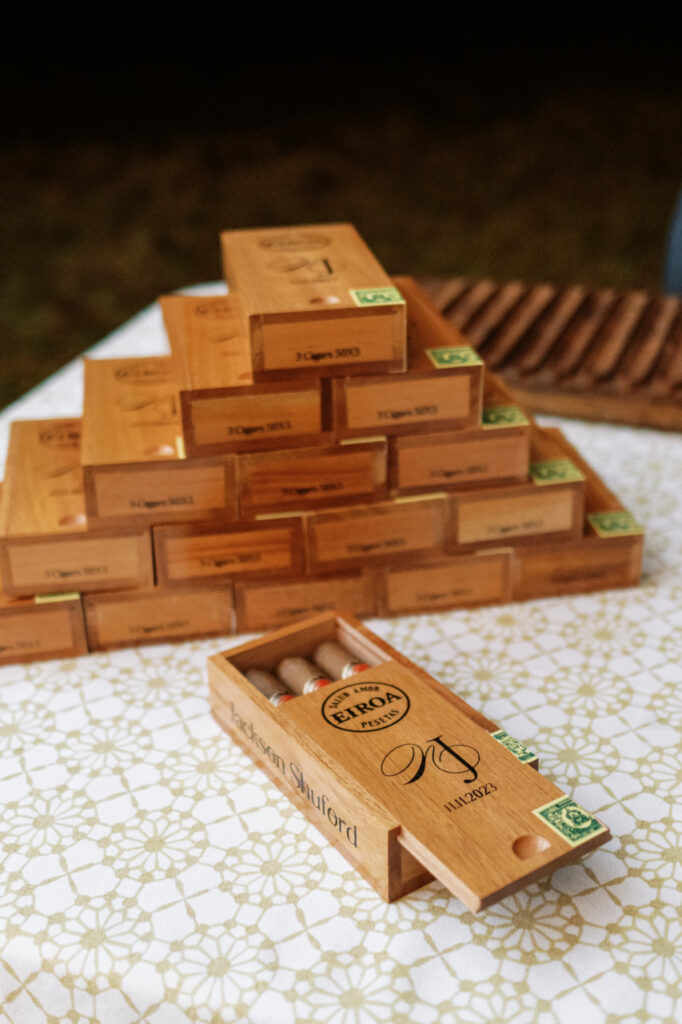 A stack of custom cigar boxes with the couple's monogram and wedding date printed on top given to guests as wedding favors.